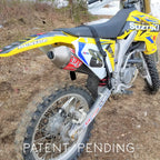 Yellow and black Suzuki dirt bike on a dirt surface with 'Patent Pending' text.